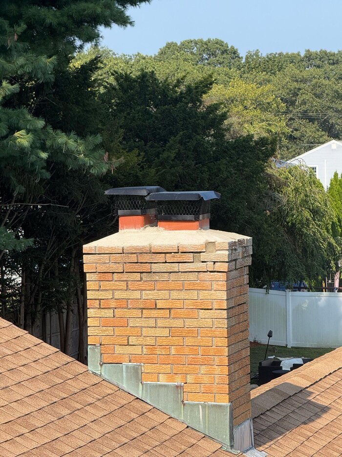 Dual flue chimney cap installed on brick chimney