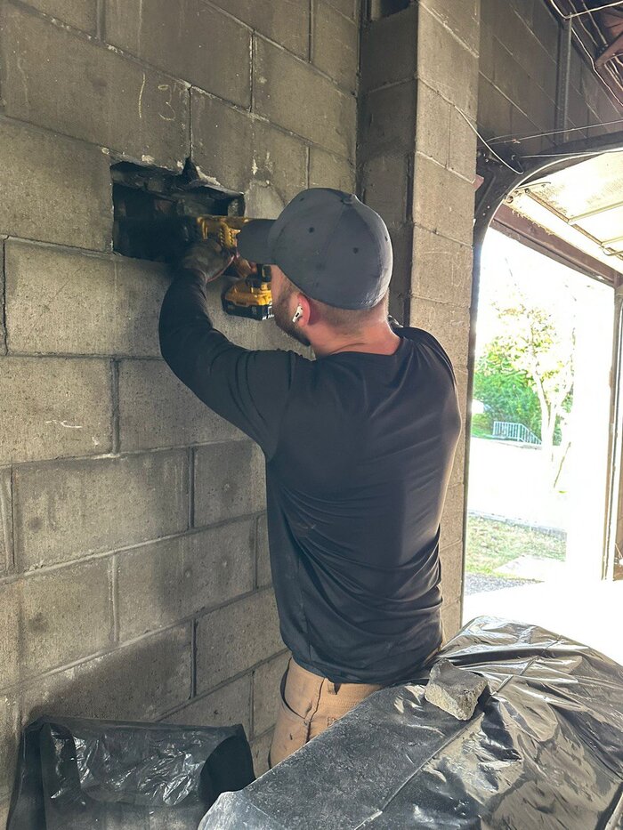 Chimney technician working on cleanout with DeWalt drill