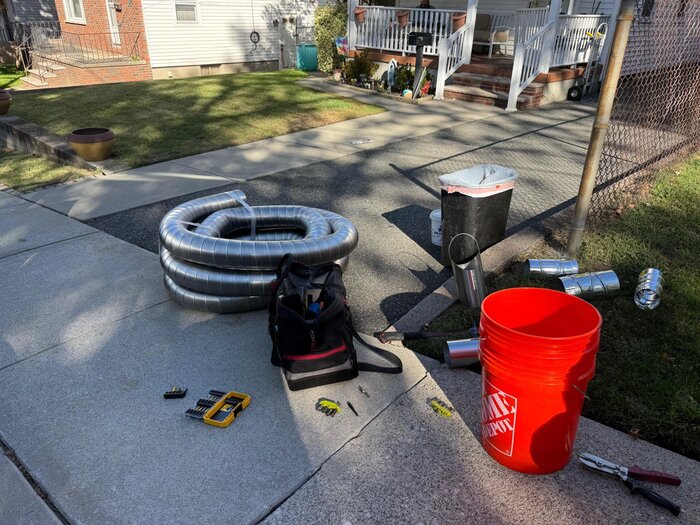 Chimney relining materials and tools laid out on driveway