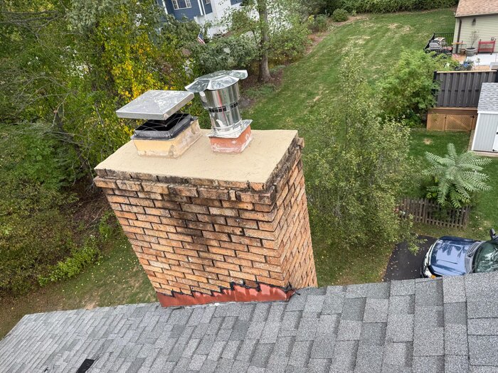 Aerial view of chimney with new crown dual caps and copper flashing